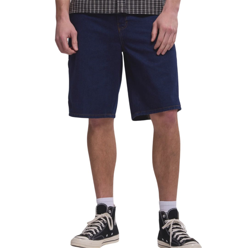 Person wearing navy blue shorts and black high-top sneakers on a white background