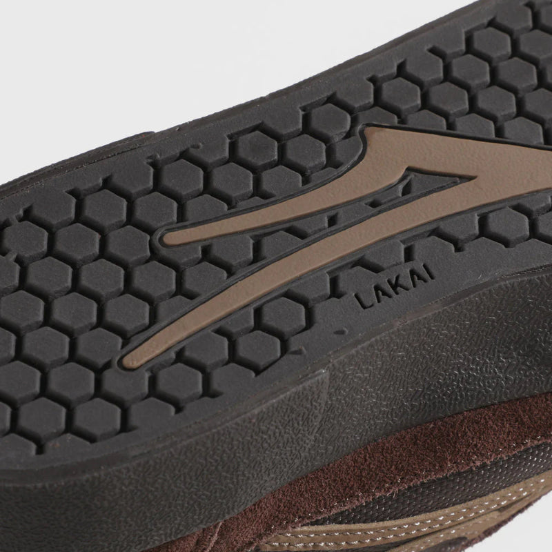 Close-up of a brown and black shoe sole with 'Lakai' branding on a light gray background