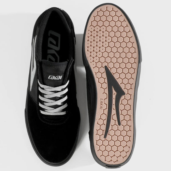 Black athletic shoe with white laces and a textured sole on a light gray background