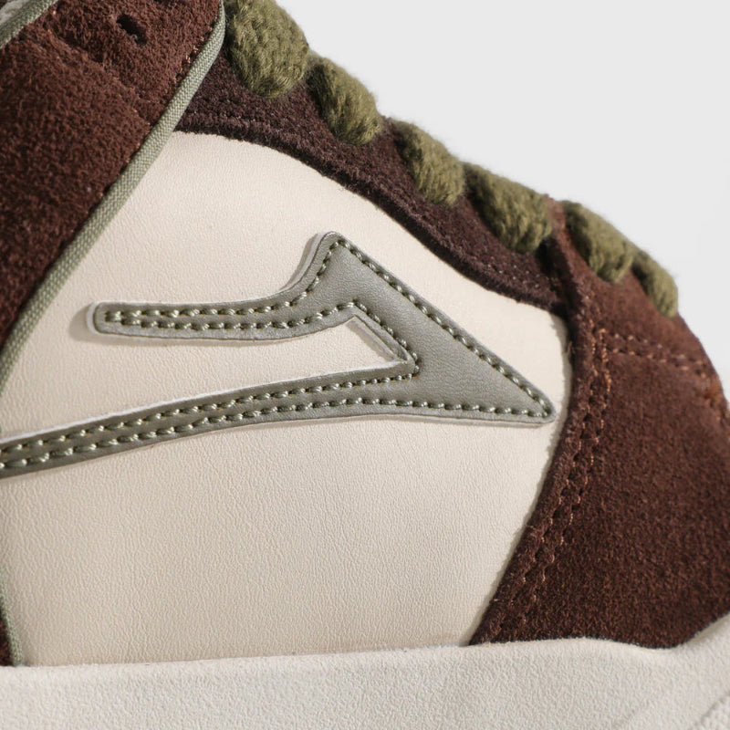 Close-up of a brown and beige sneaker with a brand logo on a white background