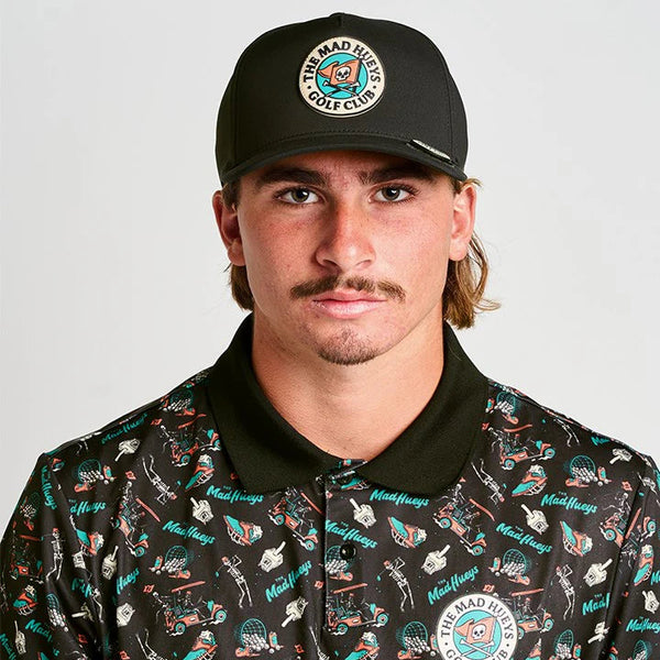 Man wearing a black cap and a patterned shirt with 'The Mad Hatter Golf Club' branding.