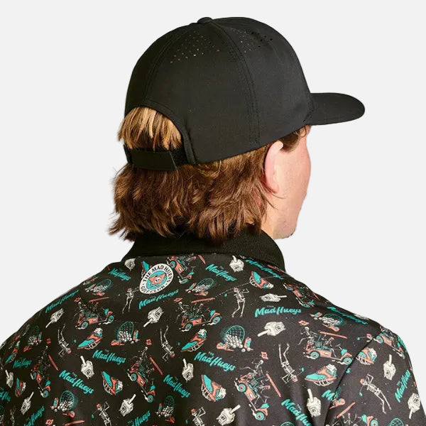 Person wearing a black cap and a patterned shirt with various designs.