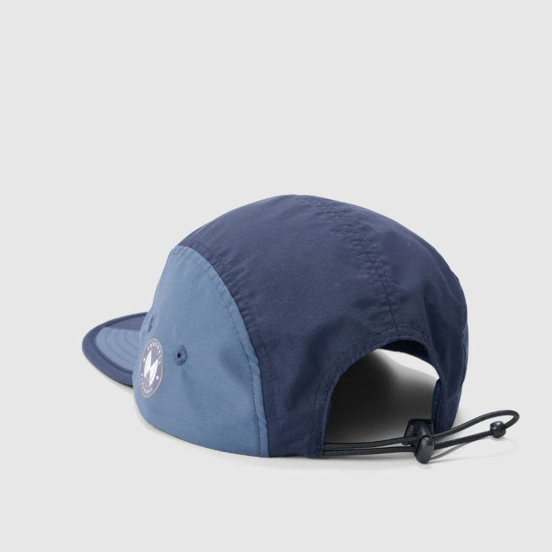 A two-tone blue 5-panel running cap shown from a side-back angle on a light gray background. The front panels are a darker navy blue, while the side panel is a lighter medium blue.