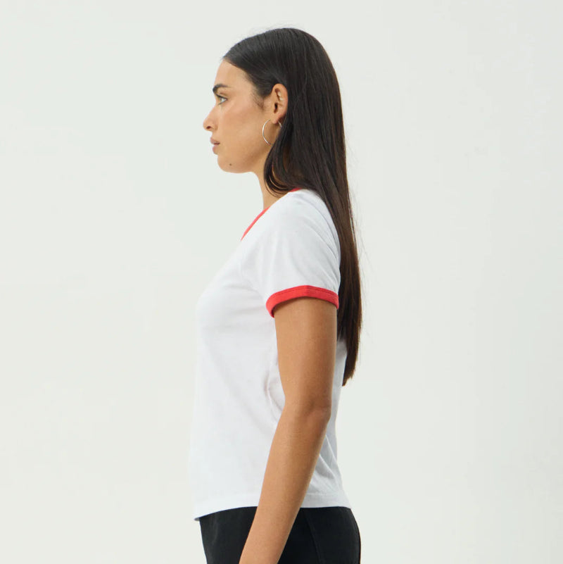 Woman wearing a white t-shirt with red trim and a black skirt on a white background
