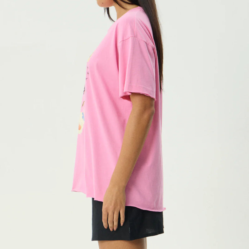 Woman wearing a pink t-shirt and black shorts on a white background