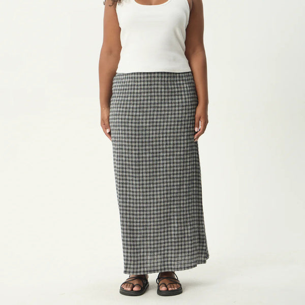 Woman wearing a white tank top and plaid skirt on a white background