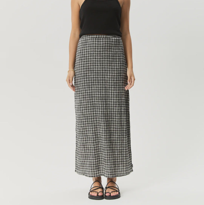 Woman wearing a black tank top and plaid skirt on a white background