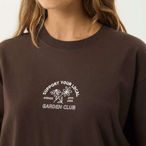 a women wearing a brown shirt with a white logo and white strips 