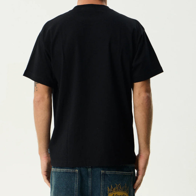 Person wearing a black t-shirt with a logo on the back, standing against a plain background