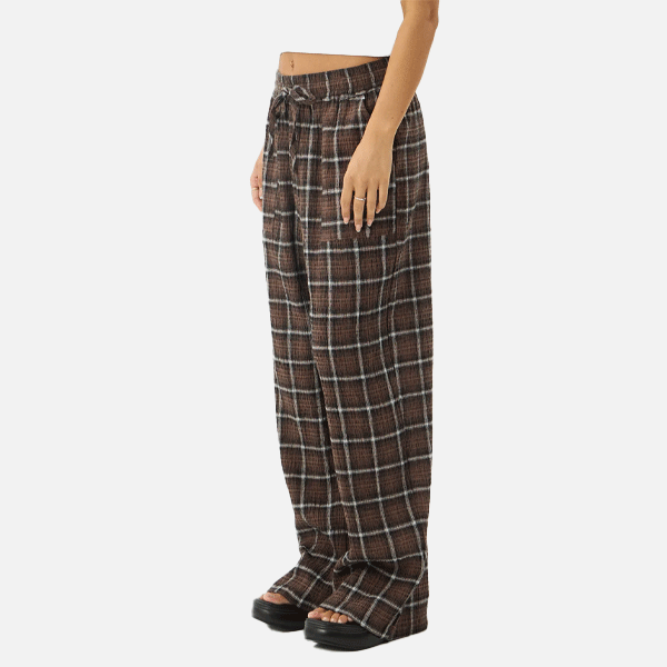 a women wearing a white crop top and brown pants