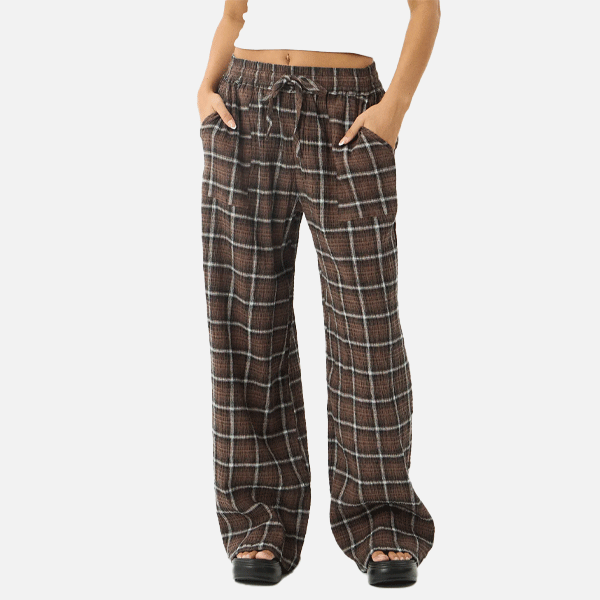 a women wearing a white crop top and brown pants