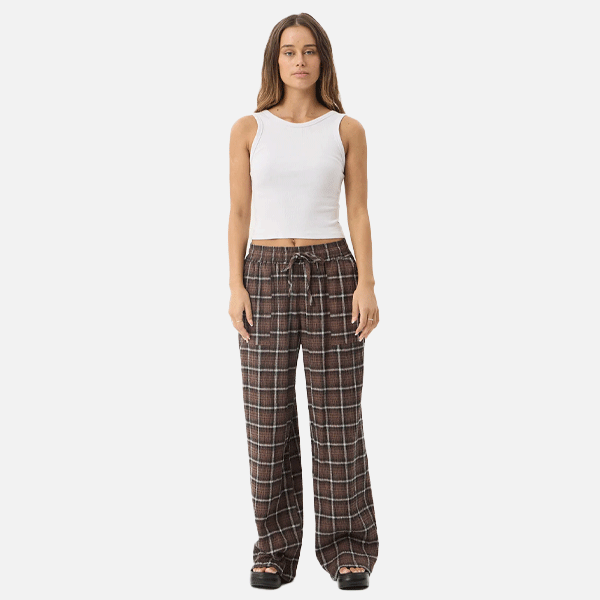 a women wearing a white crop top and brown pants
