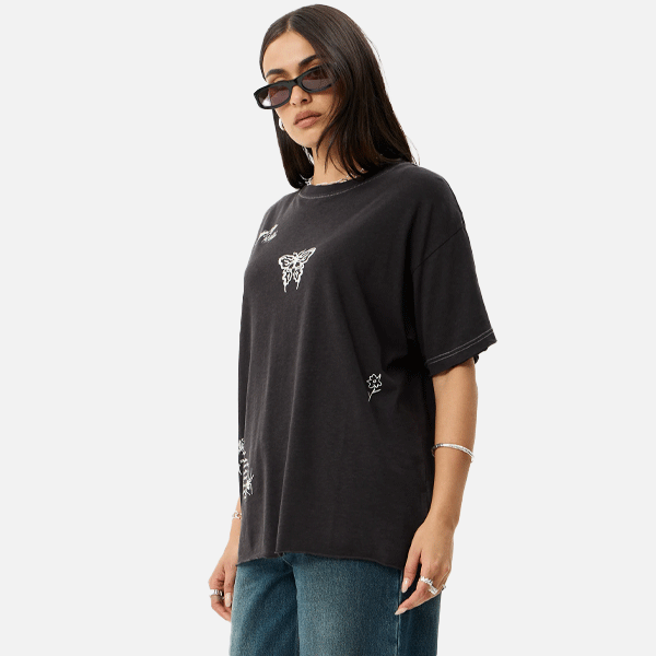 a women wearing a black t-shirt with a white logo also wearing sun glasses