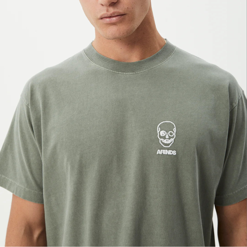 Man wearing a green t-shirt with a logo on a white background