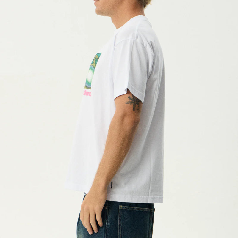Person wearing a white t-shirt with a colorful graphic on a plain background