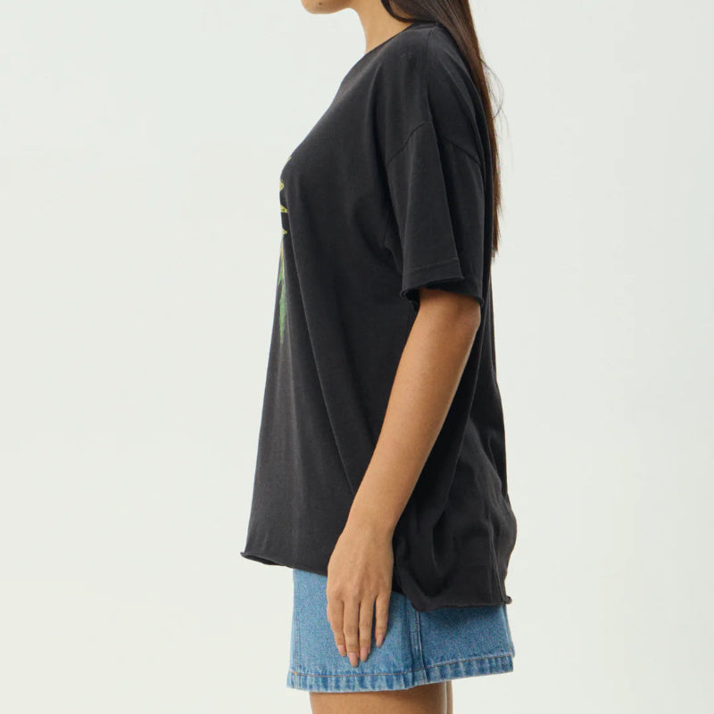Woman wearing a black oversized t-shirt and denim shorts on a white background