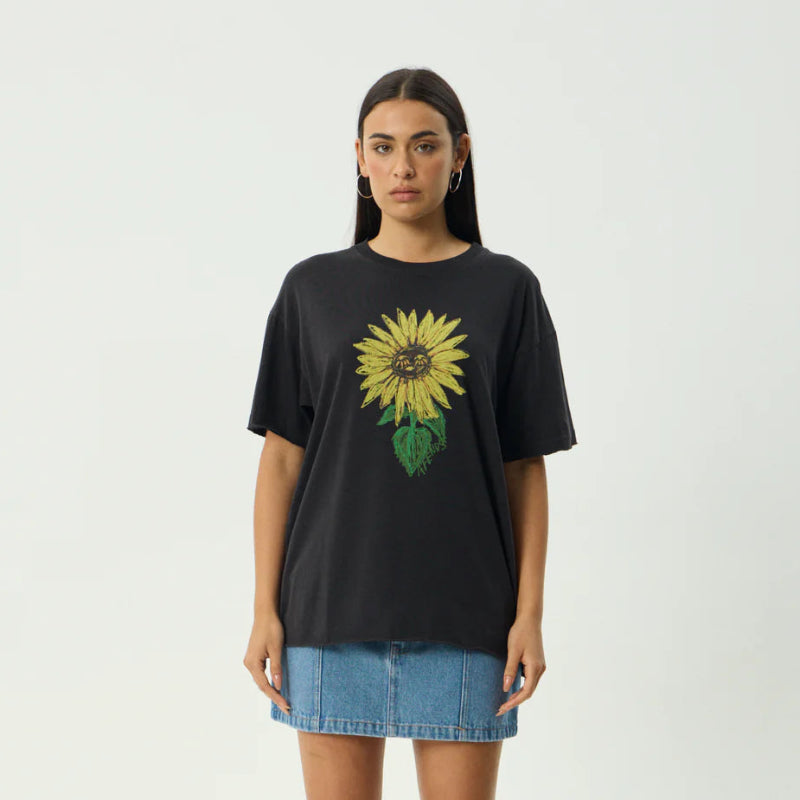 Person wearing a black t-shirt with a sunflower design on a white background