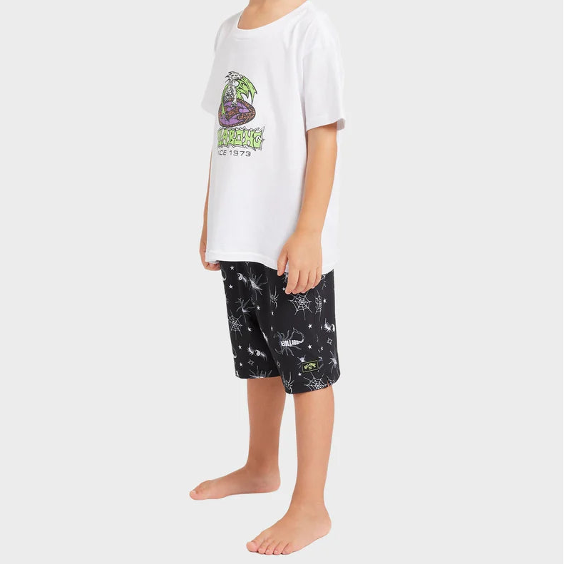 Child wearing a white t-shirt with a graphic design and black shorts with a pattern on a white background