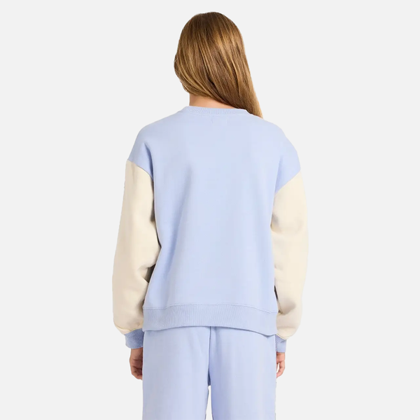 Person wearing a light blue and beige color-blocked outfit on a white background
