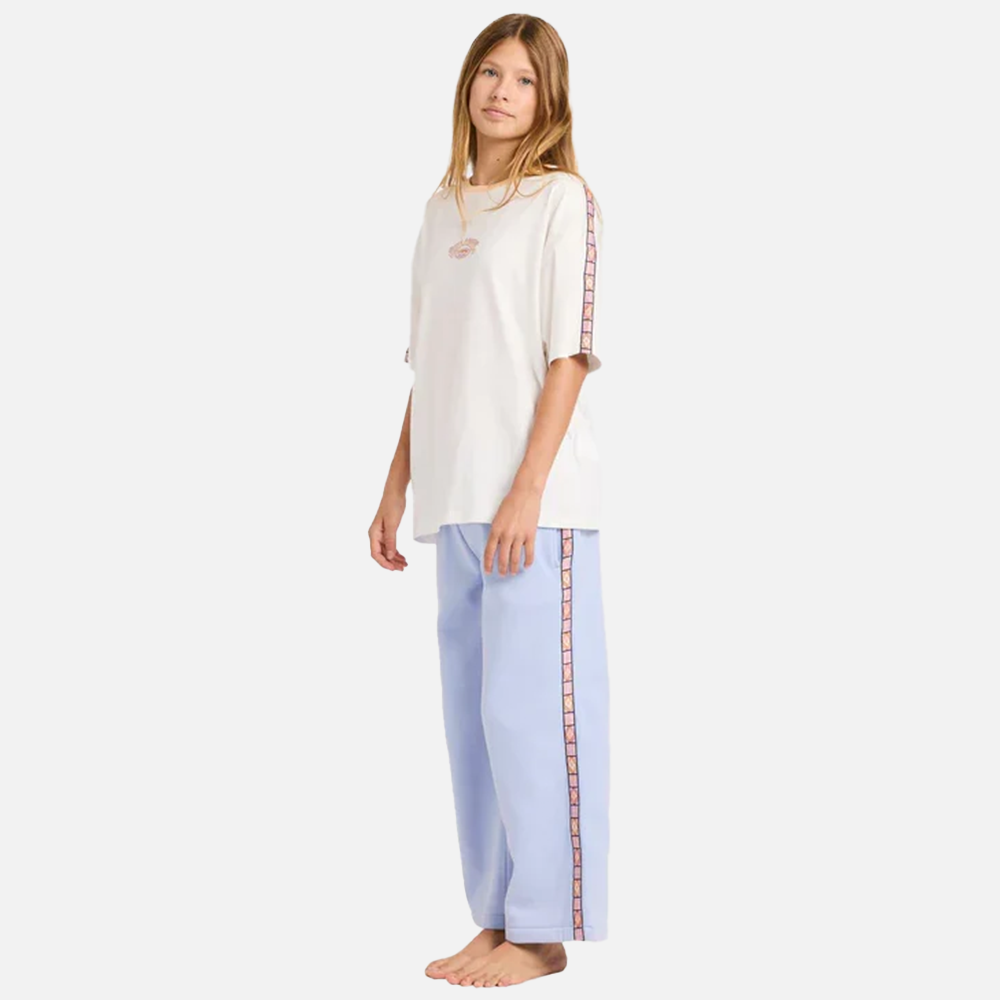 Woman wearing a white top and light blue pants with a patterned side stripe on a white background