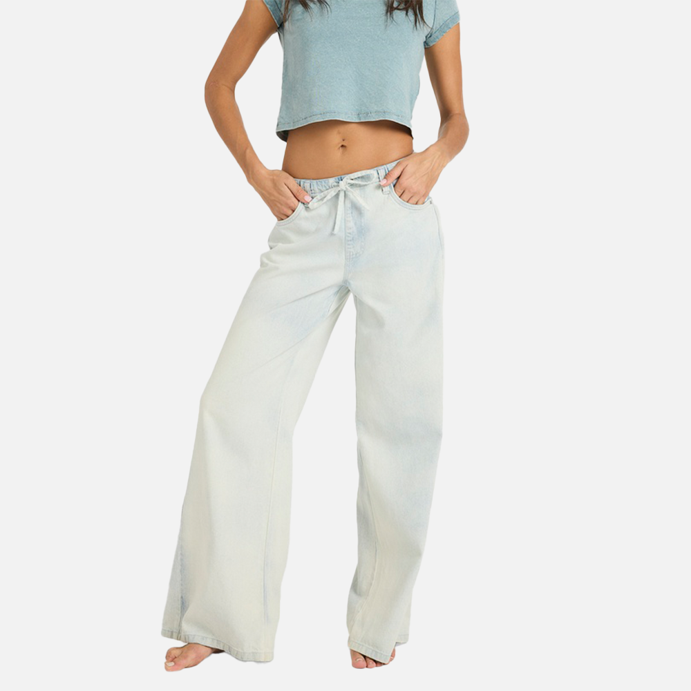 Person wearing light blue crop top and white wide-leg pants on a white background