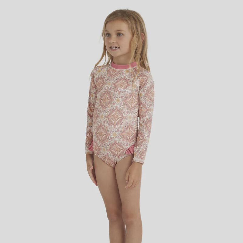 Young girl wearing a patterned long-swimsuit on a white background