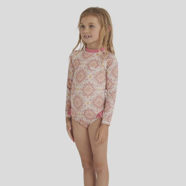 Young girl wearing a patterned long-swimsuit on a white background