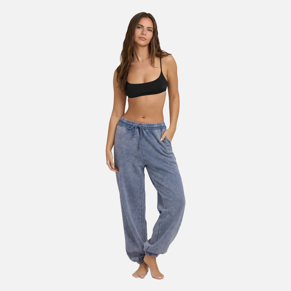 Woman wearing a black bikini top and blue denim pants on a white background