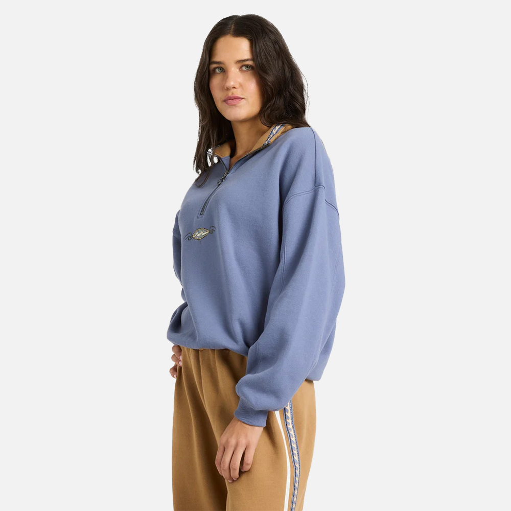 Woman wearing a blue sweatshirt and brown pants on a white background