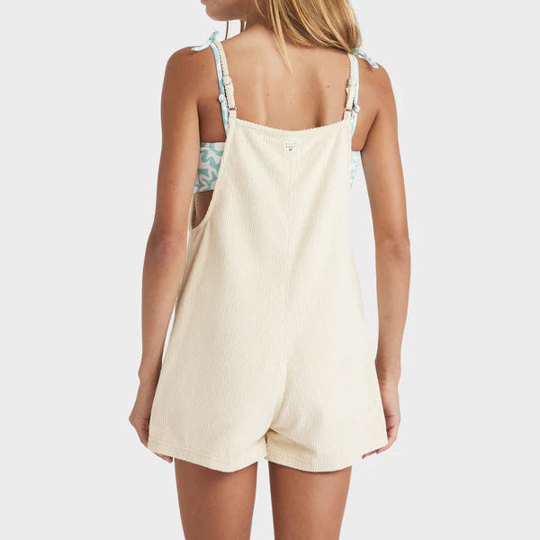 Woman wearing a beige romper with thin straps on a white background