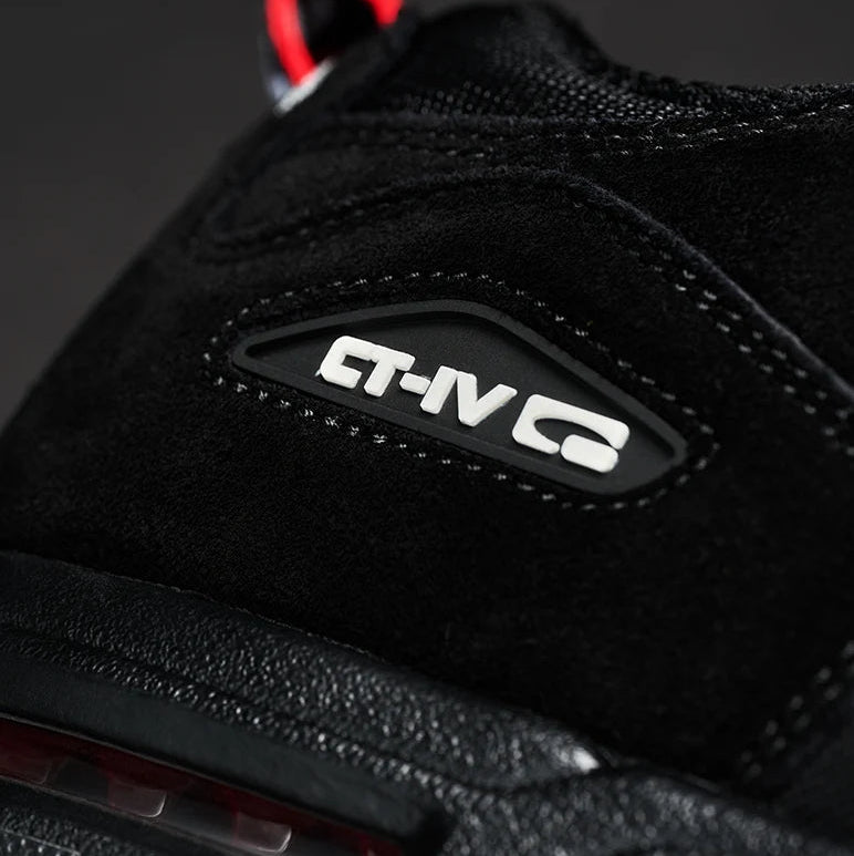 Close-up of a black suede and mesh sneaker showing the side logo patch with 'CT-IV G' in white, with a red pull tab visible at the top against a dark background.