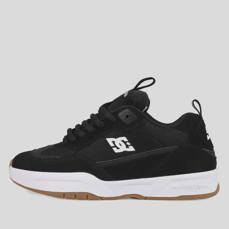 Black sneaker with white sole on a light gray background