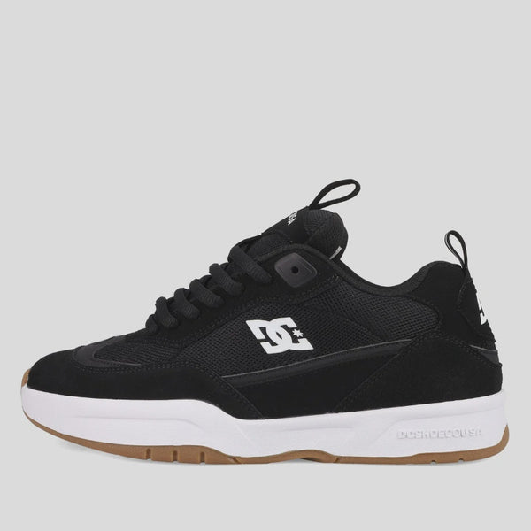 Black sneaker with white sole on a light gray background