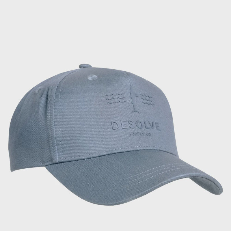 Blue baseball cap with 'DEsolve Supply Co' branding on a light gray background
