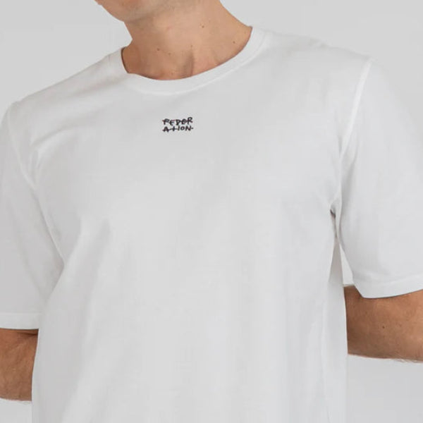 Man wearing a white t-shirt with a logo on a plain background