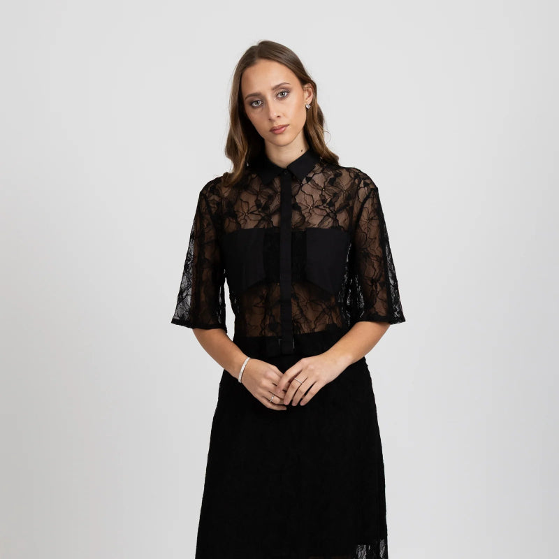 Woman wearing a black lace top and skirt on a white background