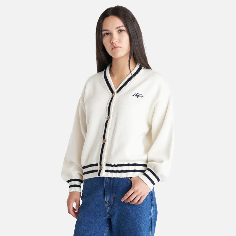 Person wearing a white cardigan with black trim and a logo on a white background