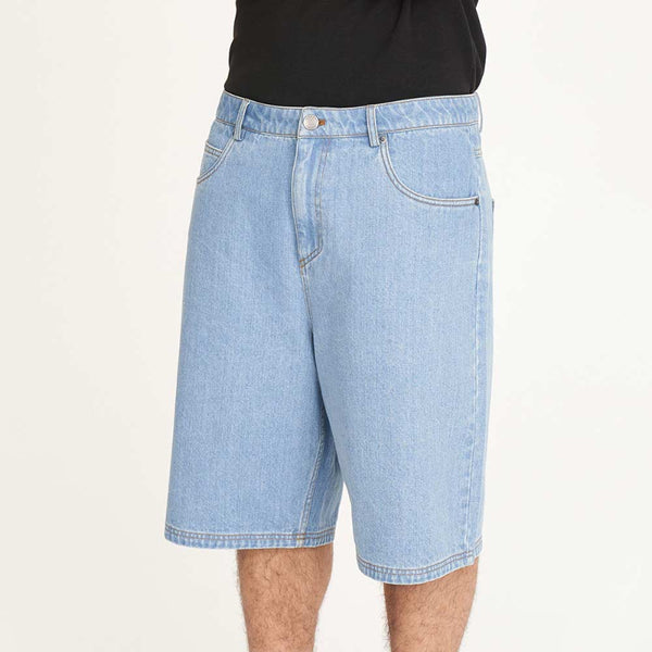 Person wearing light blue denim shorts, black Nike shoes, and white socks on a white background