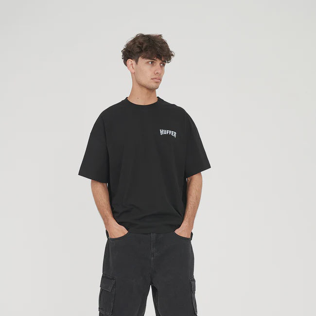 Person wearing a black t-shirt and cargo shorts on a white background