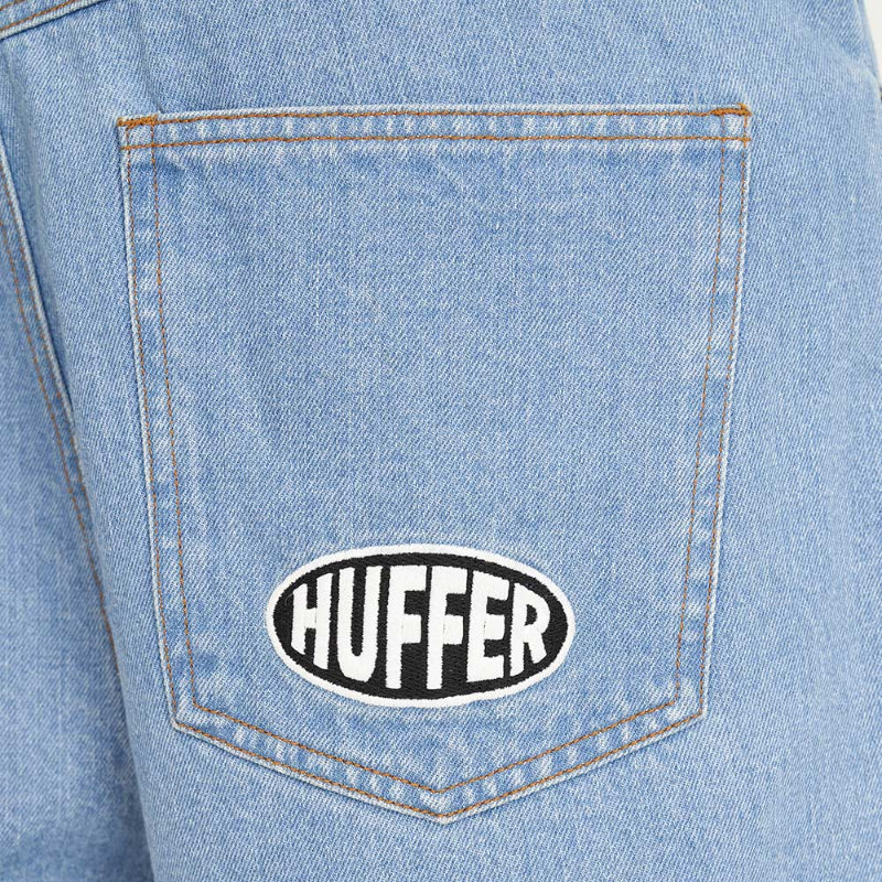 Denim pocket with 'Huffer' logo on a light blue denim background