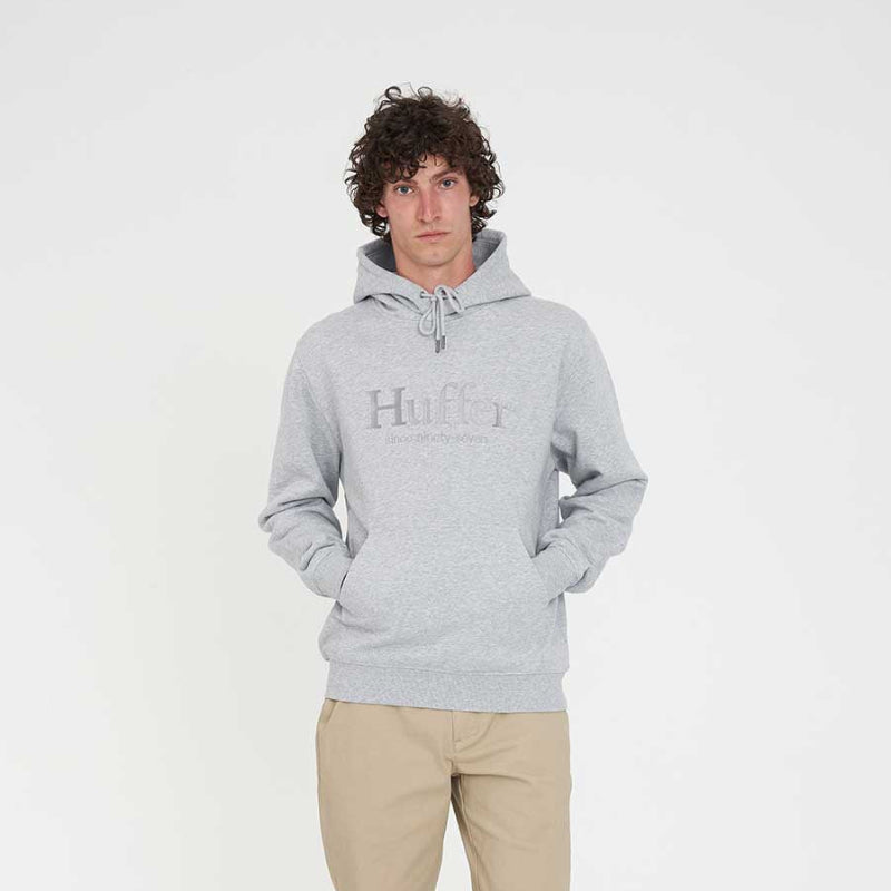 Person wearing a gray hoodie with a brand logo on a white background