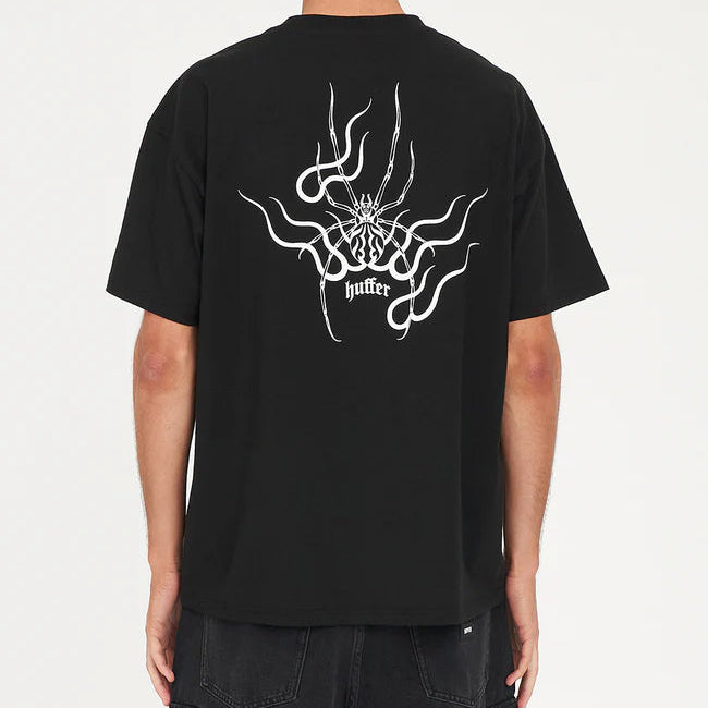 Person wearing a black t-shirt with a white graphic design on the back against a white background