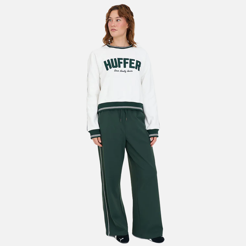 Person wearing a white sweatshirt with 'Huffer' logo and green pants on a white background