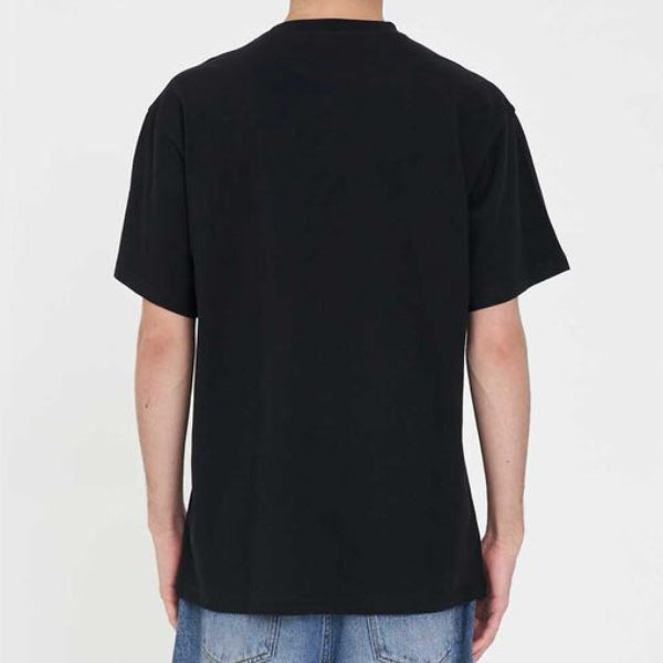 A man viewed from behind wearing a plain black short-sleeve t-shirt and blue jeans, standing against a light gray studio background.