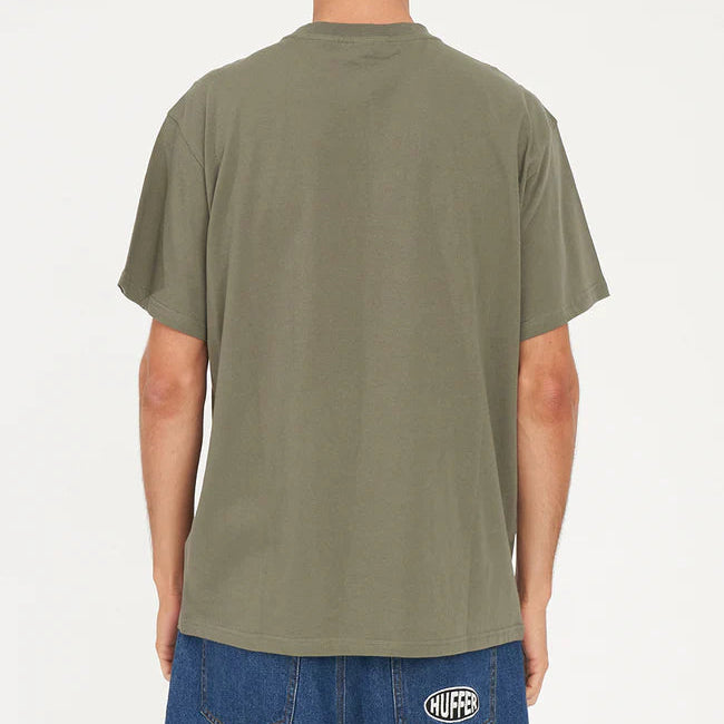 Person wearing an olive green t-shirt with a visible brand logo on a white background