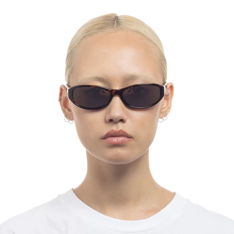 Person wearing dark sunglasses on a white background