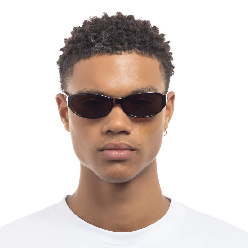 Person wearing dark sunglasses on a white background