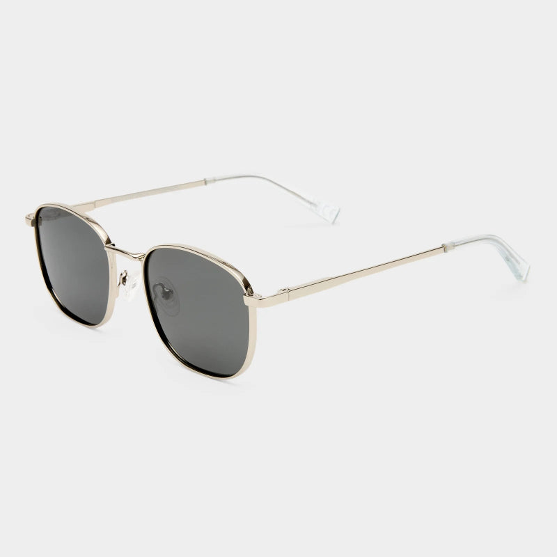 Sunglasses with silver frame and dark lenses on a light gray background