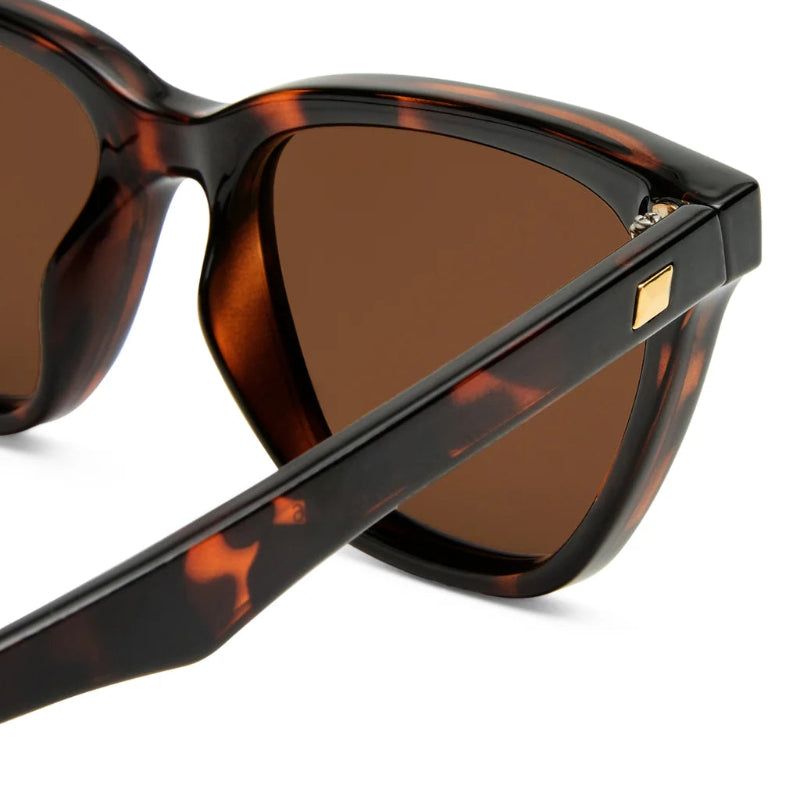 Tortoiseshell sunglasses with brown lenses on a white background