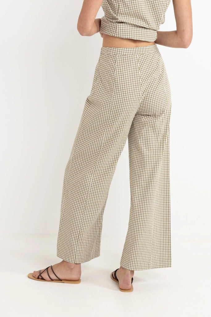 Person wearing a checkered outfit with wide-leg pants on a white background